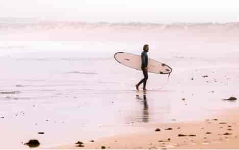 surfer in wetsuit with surfboard